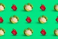 A colorful seamless pattern of young cauliflower and bell pepper on a green background. The concept of healthy food.