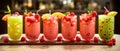 Colorful selection of milky fruit flavored bubble tea arranged in line on wooden table and bokeh background. panoramic banner