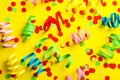 Colorful serpentine streamers and confetti on yellow background flat lay