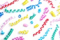 Colorful serpentine streamers on white background, top view