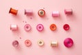 Colorful sewing accessories on pink background. Flat lay, top view, Colorful thread spools and buttons on pink background, AI