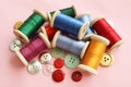 Colorful sewing threads and buttons on pink background Royalty Free Stock Photo