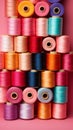 colorful sewing threads on pink background with copy