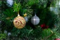 Colorful shining balls, garland, ribbons are hanging on branches of christmas tree