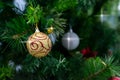 Colorful shining balls, garland, ribbons are hanging on branches of christmas tree. Decorated christmas