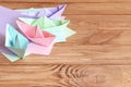 Colorful ships paper folding, sheets of colored paper on a wooden table with empty space for text Royalty Free Stock Photo