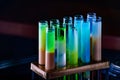 Colorful shot drinks in glass tubes. Dark background, atmospheric bar image. Laboratory glassware with alcohol cocktails