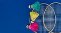 Colorful shuttlecocks and badminton rackets over blue Royalty Free Stock Photo