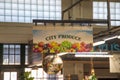 A colorful sign with bell peppers, bananas, lettuces and over colorful produce that reads City Produce at the Municipal Market