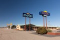 Colorful sign of the Sunset Motel with Whiting Bros. filling station in background.