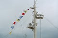 Colorful signal nautical flags against cloudy sky. Royalty Free Stock Photo