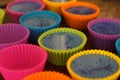 Colorful silicon cupcake molds on wooden coard filled with liquid soap for a home made hobby of melt and pour soapmaking