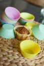 Colorful silicon molds for baking cupcakes and muffins on a straw table mat.