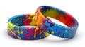 Colorful Silicone Rings with Vibrant Multicolor Paint Splatter Pattern on White Background Royalty Free Stock Photo