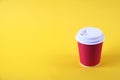 Colorful simplistic minimal composition with heat proof paper coffee cup. Take out tea mug with plastic cap. Coffee shop concept. Royalty Free Stock Photo