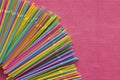 Colorful single use disposable plastic straws in the corner on the pink surface. Royalty Free Stock Photo