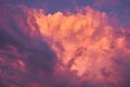 Colorful sky background with puffy clouds of pink, purple and orange after summer rainstorm