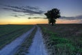 Colorful sky and clouds after sunset over the road through field Royalty Free Stock Photo