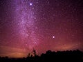 The colorful sky with clusters of stars and milkyway galaxy above the shadow of trees annd mountain, Chiangmai, Thailand.