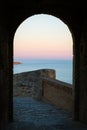 Colorful sky seen through the arch of Santa Barbara castle, Alicante, Spain. Royalty Free Stock Photo