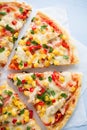 Colorful sliced pizza with mozzarella cheese, chicken, sweet corn, sweet pepper and parsley close up top view Royalty Free Stock Photo