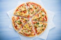 Colorful sliced pizza with mozzarella cheese, chicken, sweet corn, sweet pepper and parsley close up top view