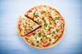 Colorful sliced pizza with mozzarella cheese, chicken, sweet corn, sweet pepper and parsley top view Royalty Free Stock Photo