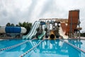 Colorful slide variety and turquoise swimming pool at a hotel. Fun fast slides in an aquapark. Summer vacation amusement ideas. Royalty Free Stock Photo