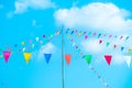 Colorful small flags in the sky. Waving small colorful flags hanging on the rope for holidays against blue sky Royalty Free Stock Photo