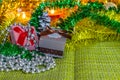 Colorful small gift boxes with gifts among Christmas tinsel and shiny toys and decorations Royalty Free Stock Photo