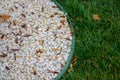 Colorful small pebbles or stone texture in garden with difference color and small green grass texture on the right