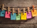 Colorful smiley notes displayed on a rustic string with clothespins against a wooden background Royalty Free Stock Photo