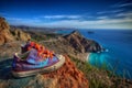 Colorful sneakers with orange laces on top of a mountain overlooking the blue sea or ocean, thirst for travel or Royalty Free Stock Photo