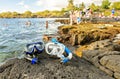 A Colorful snorkle or diving mask located on the rocks with snorkling group on the back Royalty Free Stock Photo