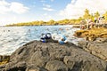 A Colorful snorkle or diving mask located on the rocks with snorkling group on the back Royalty Free Stock Photo