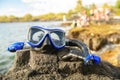 A Colorful snorkle or diving mask located on the rocks with snorkling group on the back Royalty Free Stock Photo