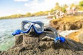 A Colorful snorkle or diving mask located on the rocks with snorkling group on the back Royalty Free Stock Photo