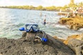 A Colorful snorkle or diving mask located on the rocks with snorkling group on the back Royalty Free Stock Photo