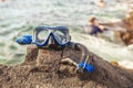 A Colorful snorkle or diving mask located on the rocks with snorkling group on the back Royalty Free Stock Photo