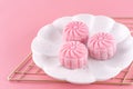 Colorful snow skin moon cake, sweet snowy mooncake, traditional savory dessert for Mid-Autumn Festival on pastel pale pink backgro