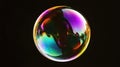 Colorful soap bubble floating against a dark background, showcasing vibrant reflections and intricate patterns, creating a Royalty Free Stock Photo