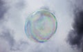 Colorful soap bubble floating in an overcast sky