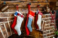 Colorful socks for a gift from Santa Claus hang on the fireplace.