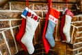 Colorful socks for a gift from Santa Claus hang on the fireplace.