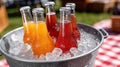Colorful soda bottles in ice bucket at a summer picnic setting. Royalty Free Stock Photo