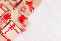 Colorful soft various celebration gifts with red bows and ribbons on white wood table, flat lay, border. Royalty Free Stock Photo