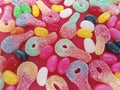 Colorful sour key candies and jelly beans on a red background