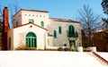 Colorful Southwestern House on hill in the Snow with steps leading up to it Royalty Free Stock Photo