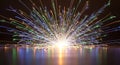Colorful sparks exploding outwards from a central light source on a reflective surface Royalty Free Stock Photo