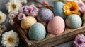 Colorful Speckled Easter Eggs in Rustic Wooden Tray Surrounded by Spring Flowers on Gray Background Royalty Free Stock Photo